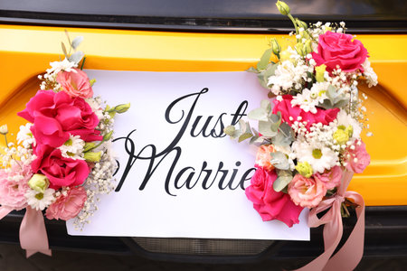 Wedding car. Cabriolet decorated with Just Married card and beautiful flowers outdoors, closeupの写真素材