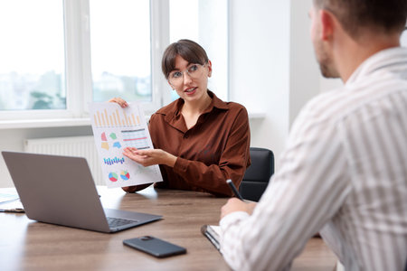 Consultant working with client at table in office. Business meeting