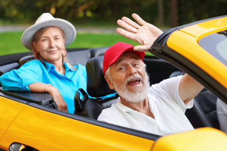 Senior couple enjoying cabriolet ride outdoors, selective focus