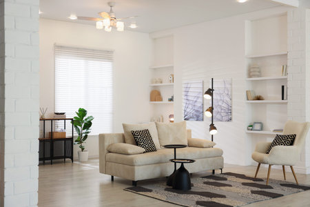 Stylish living room with lamp, houseplant and sofa. Interior design