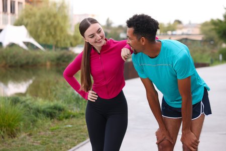 Smiling runners resting outdoors. Space for text