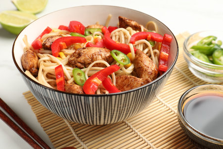 Delicious noodles with meat and vegetables served on white table, closeup