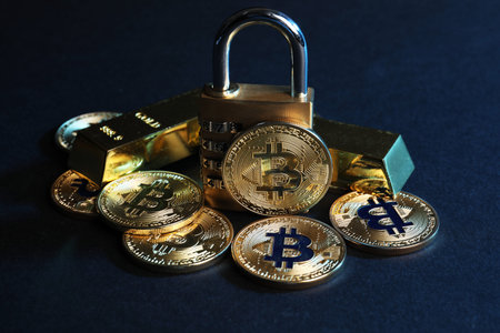 Bitcoins, padlock and gold bars on blue background, closeup