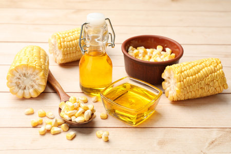 Corn butter, kernels and cobs on white wooden table