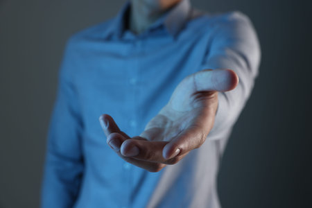 Man holding something on gray background, closeup