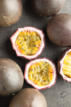 Fresh passion fruits on gray table, flat lay