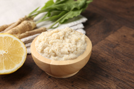 Tasty horseradish sauce and roots on wooden table, closeupの写真素材