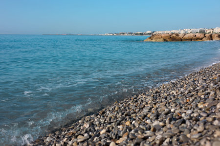 Beautiful view of wavy sea and pebbles on beach