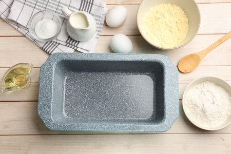 Baking dish and different ingredients for corn bread on light wooden table, flat lay. Space for textの写真素材