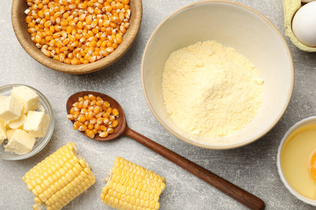 Cornbread preparation. Different ingredients on light gray table, flat lay