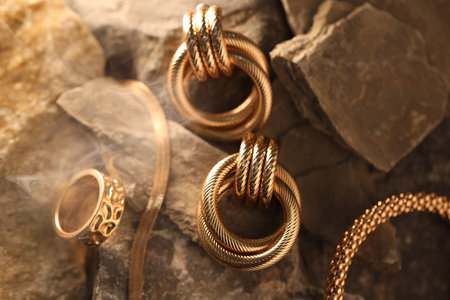 Different stylish gold jewelry in smoke on rocks, closeupの写真素材