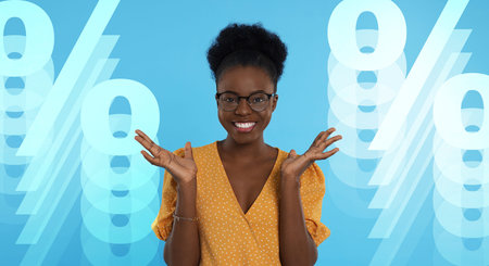 Amused woman and percent signs on light blue background