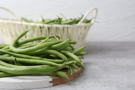 Fresh green bean pods on gray table, closeup. Space for text