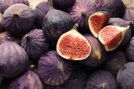 Whole and cut figs as background, top view
