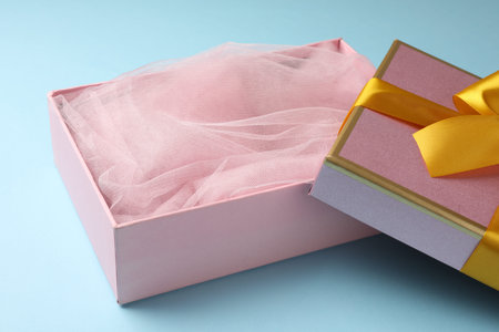 Opened gift box with beautiful lid on light blue background, closeupの写真素材