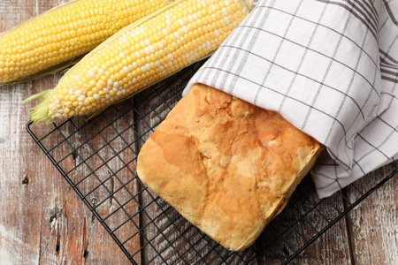 Freshly baked cornbread and cobs on wooden table, flat lay
