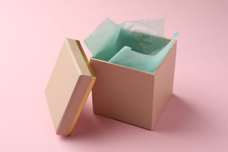 Open gift box with lid on pink background