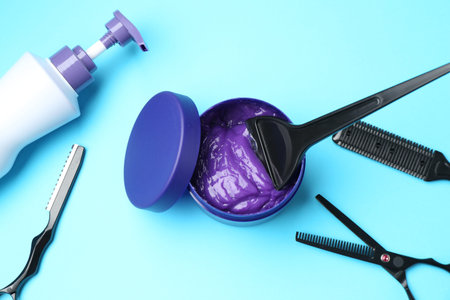 Care cosmetic product for blonde hair in jar and hairdresser's tools on light blue background, flat layの写真素材