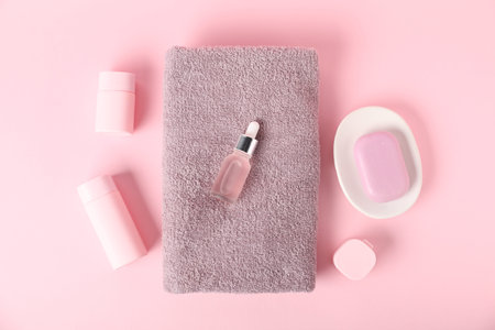 Fresh terry towels and cosmetic product on pink background, flat layの写真素材