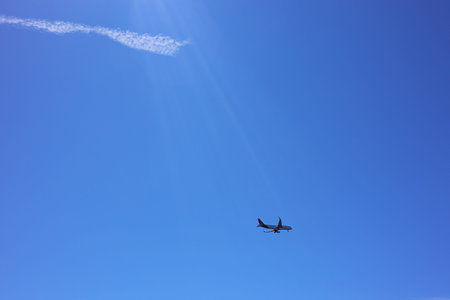 Airplane flying in beautiful blue sky, bottom view