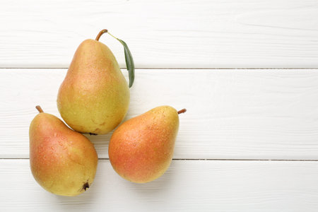 Fresh ripe pears on white wooden table, flat lay. Space for textの写真素材