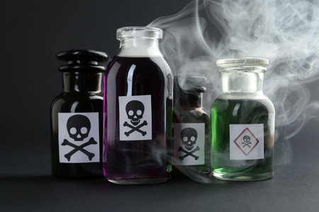 Bottles with warning signs and smoke on dark background, closeupの写真素材