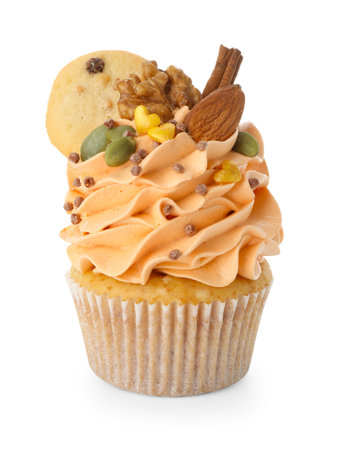 Delicious cupcake with sprinkles, nuts, cookies and spices isolated on white. Autumn atmosphereの写真素材