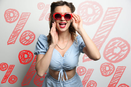 Amused woman against light background with drawn red percent signs