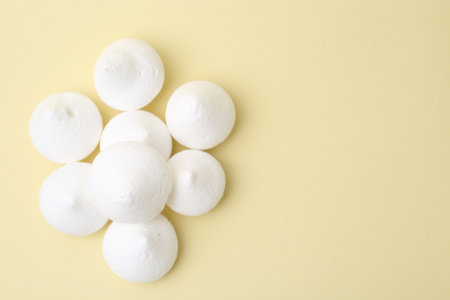 Yummy meringue cookies on beige background, flat lay. Space for textの写真素材