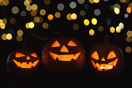 Halloween jack-o-lanterns. Pumpkins with carved creepy faces, bokeh effectの写真素材