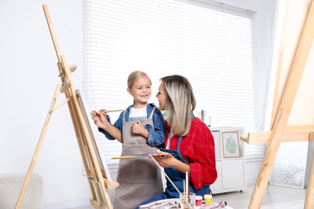 Choice of profession. Mother teaching her daughter to paint in studioの写真素材