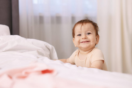 Cute little baby near bed at home