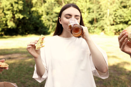 Group of friends having fun and drinking outdoors