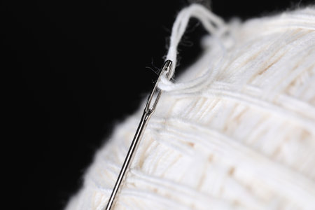 Sewing needle with white thread on black background, macro viewの写真素材