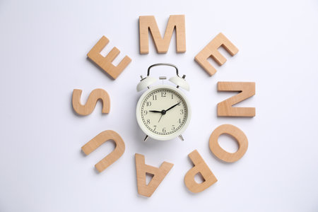 Word Menopause and alarm clock on white background, top viewの写真素材