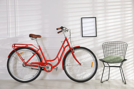 Red bicycle, chair and empty frame on white wall indoorsの写真素材