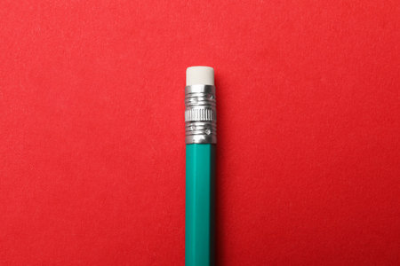One pencil on red background, top view