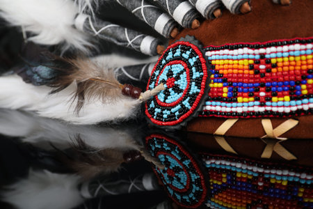 Traditional warbonnet (Native American chief headdress) on black mirror surface, closeup
