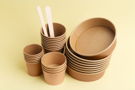Set of disposable tableware on beige background, closeup