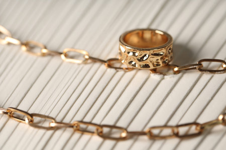 Stylish gold necklace and ring, closeup