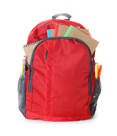 Red backpack with different stationery isolated on white