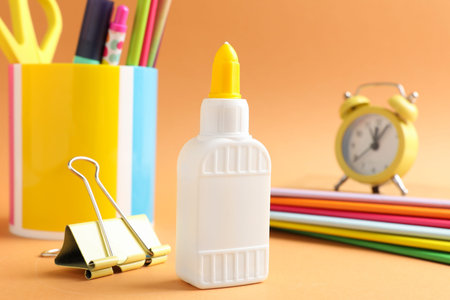 Glue and other stationery on pale orange backgroundの写真素材