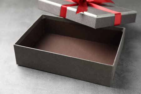 Opened gift box with beautiful lid on gray table, closeupの写真素材