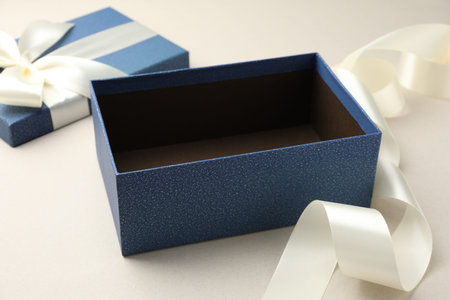 Open gift box with beautiful lid on light gray background