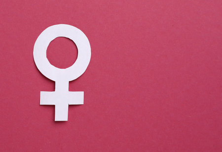 Menopause. Female gender symbol on crimson background, top view. Space for textの写真素材
