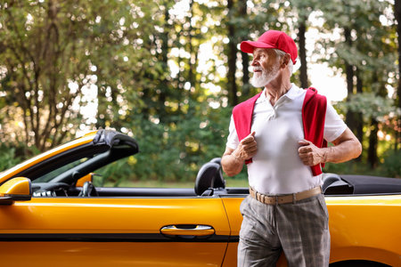 Stylish senior man near modern cabriolet outdoors