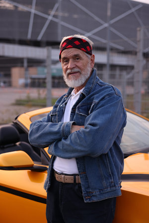 Stylish man senior near modern cabriolet outdoors