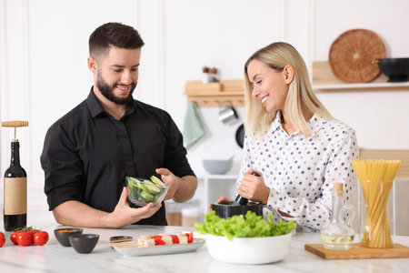 Happy couple cooking together at table in kitchen