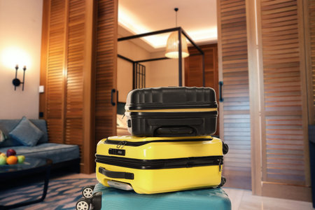 Stylish hotel room with guest suitcases, selective focus