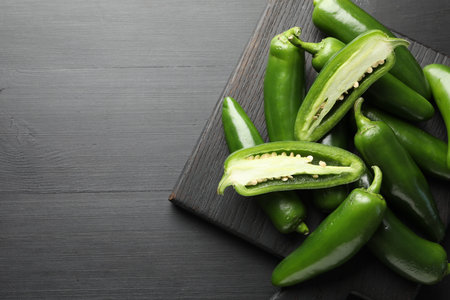 Fresh jalapeno peppers on black wooden table, top view. Space for textの写真素材
